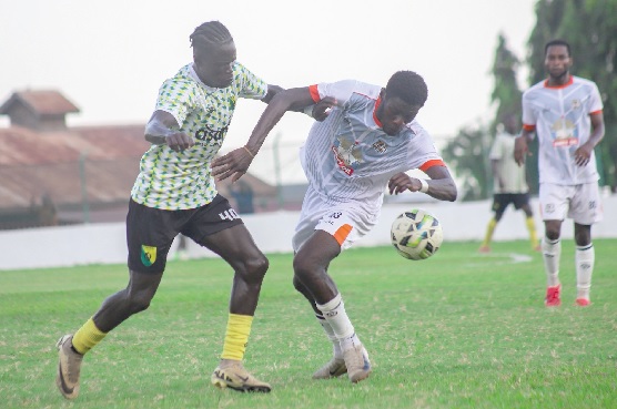 Nations FC's Isaac Asare controls the ball away from his Bibiani Gold Stars marker Barimah Baah (left) during their clash at the Dun's Park