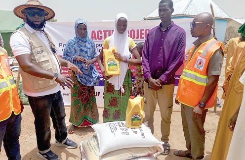 Lukman Yussif (left), Director of CLIP, supported by Mahama Zakaria (right), Savannah Regional Director of NADMO, presenting the items to the victims