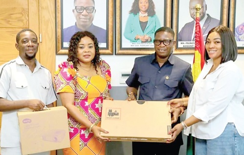 Tanko Rashid-Computer (2nd from right), Administrator, GIFEC, presenting one of the laptops to Betty Krosbi Mensah (2nd from right), the Senior Technical Advisor to the Minister of Sports and Recreation