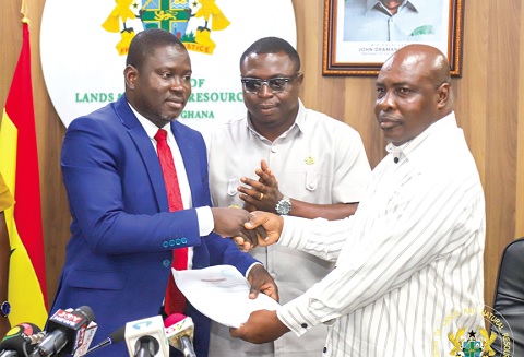 Maxwell Y. A. Klu (left), Chairman of the Tender Committee on the Damang Mines, presenting the evaluation report to Innocent Haligah (right), Chief Director of the Ministry of Lands and Natural Resources, during the event 