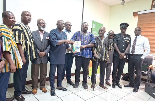 Dr Godwin Kafui Ayetor (in smock), Chairman of the Toyota Voxy Vehicles Investigative committee,  presenting a copy of the report to Abraham Amaliba, Director-General of the NRSA