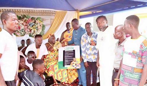 Nana Kwaku Ackon, the Owirenkyiman Youth Chief, and some committee members presenting a citation to Ehunabobrim Prah Agyensaim, Paramount Chief of Owirenkyiman Traditional Area, at a fundraising ceremony