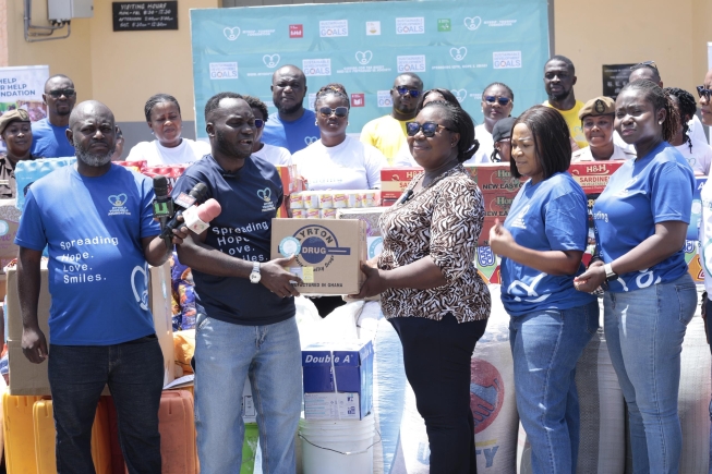 Mr Nicholas Cofie, President of the MyHelp–YourHelp Foundation, presenting relief items to Mrs Victoria Adzewodah, Deputy Director of Prisons at the Nsawam Female Prison, during the Foundation’s Easter outreach. 