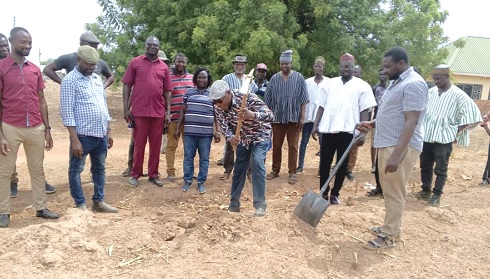 Dr Clement A. Apaak (with pickaxe raised), Deputy Education Minister, cuts the sod for the commencement of work on the projects, while guests look on