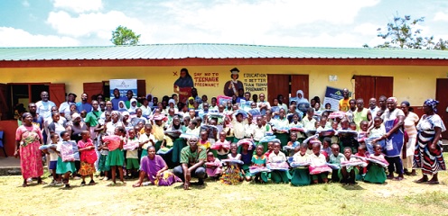 Pupils of English/Arabic Basic School, Dehia, display their backpacks. With them are parents and executives of Golden Height Foundation