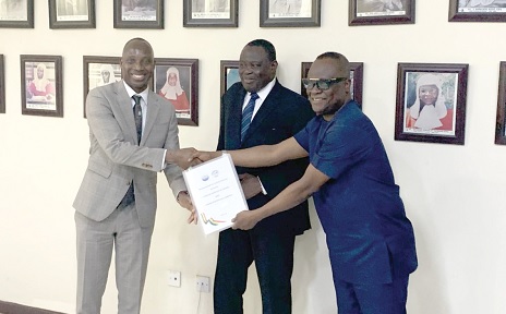 Dr Alhassan Iddrisu (left), the Government Statistician; Justice Gabriel Pwamang (middle), the Deputy Chief Justice, and Musah Ahmed (right), Judicial Secretary, holding a copy of the signed memorandum of understanding between the Ghana Statistical Service and the Judicial Service