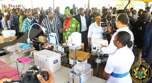 Prof. Samuel Kaba Akoriyea (arrowed), Director-General of the Ghana Health Service, explaining to President John Dramani Mahama (in smock) and other government officials some uses of various health equipment during the exhibition