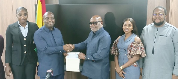  Thomas Nyarko Ampem (2nd from left) receiving a cheque from Kenneth Mpare (3rd from right), KGL Executive Director, alongside other staff members of the KGL Group