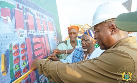 President John Dramani Mahama (right) being assisted by some chiefs to cut the ribbon for the Kukuo 24-hour Economy Market 
