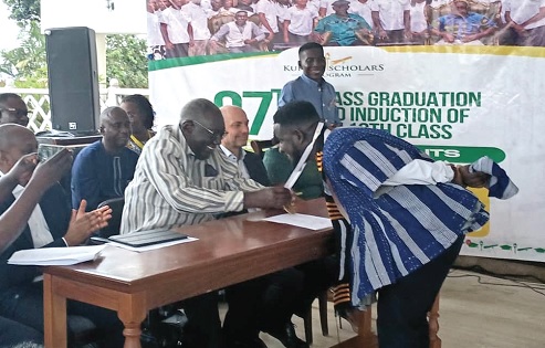 Nereus Mensah Gyasi, one of two outstanding graduates, receiving a medal from former President J. A. Kufuor