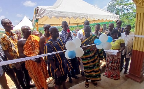 Nana Oturoku Danquah III (middle), Chief of Owuratwum Community, unveiling the plague to inaugurate the new facility (inset).Looking on are the officials of ACA and the community