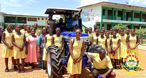 Students of one of the beneficiary schools posing by their tractor