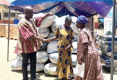 Jerry John Foreigner Modjifa Tanihu Mills-Nkrumah, District Chief Executive for Ada West, presenting items to some women beneficiaries