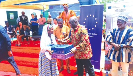Eric Opoku (middle), Minister of Food and Agriculture, presenting birds to a beneficiary