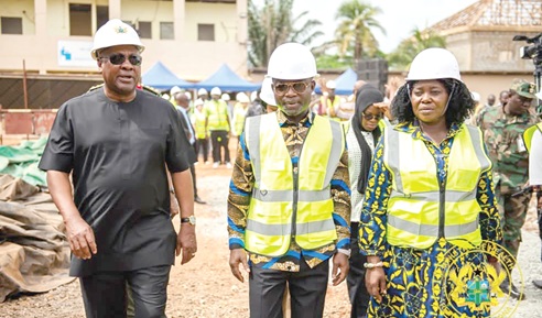 President John Dramani Mahama (left) with Kwabena Mintah Akandoh (2nd from left), Minister of Health, and Rita Odoley Sowah (right), Deputy Minister of Local Government, Chieftaincy and Religious Affairs, during a visit to the hospital site. INSET: The project