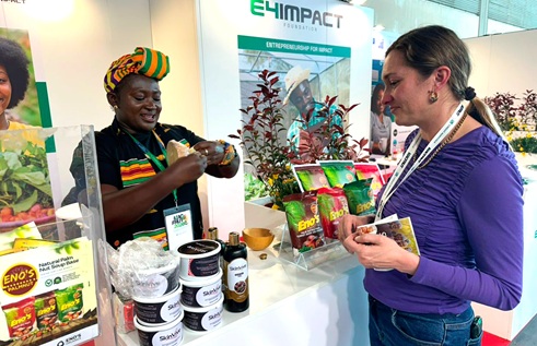 Esther Kyerewaa Twumasi (left), Founder of SkinVive, explaining the use of skinvive as a chemical-free skincare product to a client at the exhibition grounds
