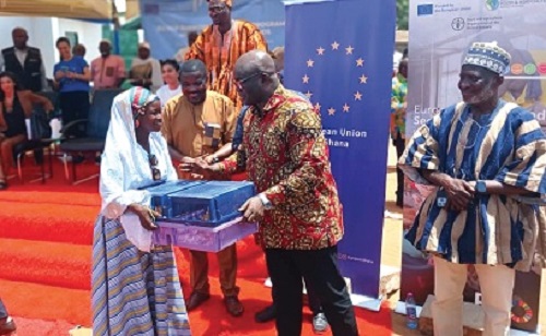 Eric Opoku (middle), Minister of Food and Agriculture, presenting birds to a beneficiary