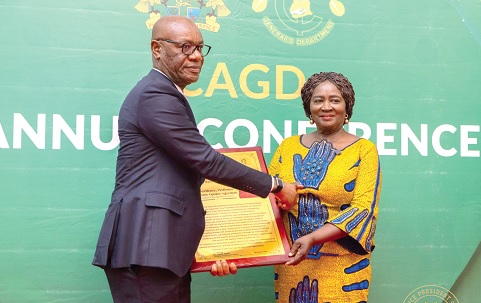 Kwasi Agyei (left), the Controller and Accountant-General, presenting a citation to Vice-President Prof. Naana Jane Opoku-Agyemang for her distinguished  public service