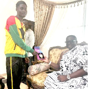Amadu Mohammed (left) presenting his medal to Nii Kojo Ashifie Papanyira I, Development Chief of Ga Mashie