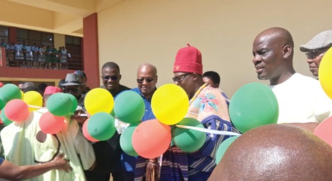 President John Mahama being supported by Pe Gideon Awolugu (2nd from right), Chief of Nakolo, and Nikyema Billa Alamzy (2nd from left), MP, Chiana-Paga Constituency, to cut the ribbon while Haruna Iddrisu (right), Minister of Education, looks on