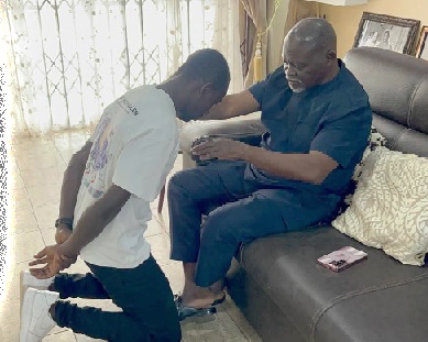 Azumah Nelson (seated) praying for John Laryea during their visit to his house