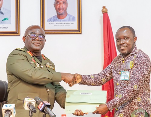 Maj. Gen. Maxwell Obuba Mantey presenting a licence to Michael Akuamoah Boateng, Agronomist at MJ Adom Limited