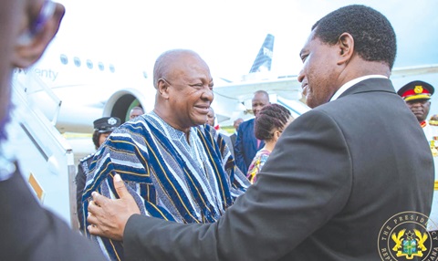 Hakainde Hichilema (right), President of Zambia, in a hearty chat with President John Dramani Mahama
