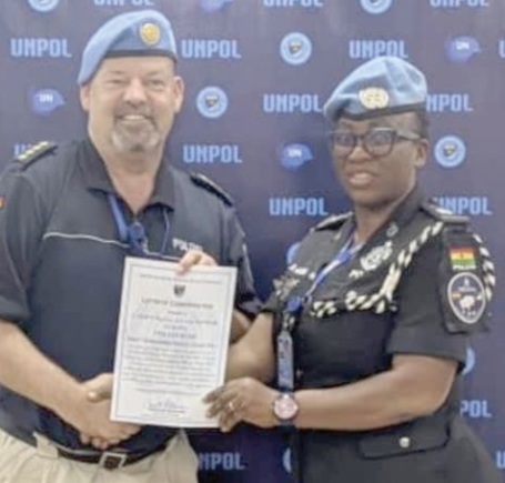 Meinolf Schlotmann (left), UN Police Commissioner, presenting a certificate to C/Supt. Rosina Adwoa Donkor Gariba