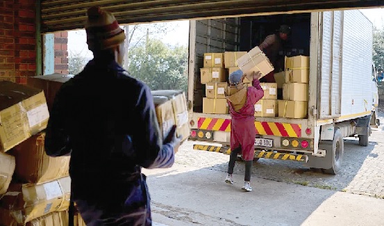 Workers loading a truck with the boxes filled with clothes from the empty Tzicc clothing factory 