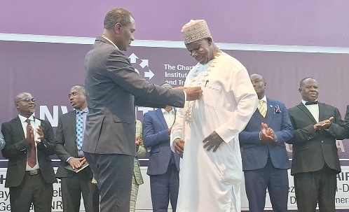 Alhaj Mohammed Saaka Dumba (right), President of CILT Ghana, being adorned with the seal of office by the immediate-past President, Mark Amoamah.