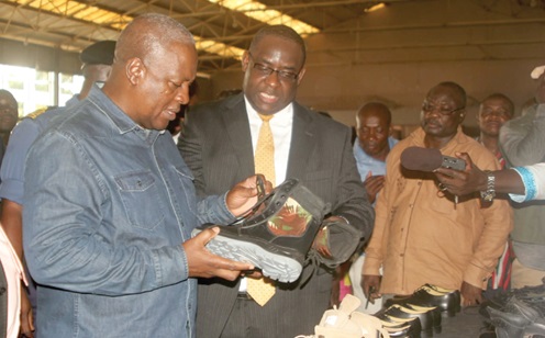 FLASHBACK: Dr Karl Laryea (right), Board Chairman of Knights Ghana Limited, showing President John Dramani Mahama some of the shoes produced at the factory when he visited in 2014