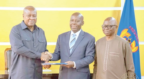 Prof. Aaron Lawson (2nd from right), Chairman of the committee, presenting the final report to President Mahama (left)