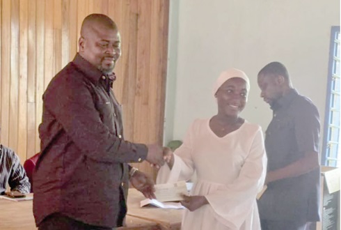 Alhaji Seidu Haruna (left), MP for Wenchi, presenting a cheque to one of the beneficiaries