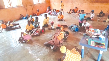 Pupils sitting on the bare  floor for lessons