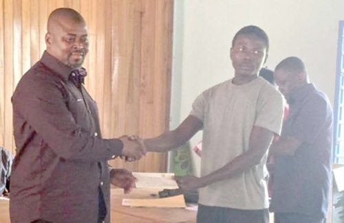 Alhaji Seidu Haruna (left), Member of Parliament (MP) for Wenchi, presenting a cheque to one of the 268 beneficiaries