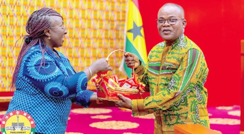 Abla Dzifa Gomashie (left), Minister of Tourism, presenting a chocolate hamper to Ebenezer Ahumah Djietror, the  Clerk to Parliament