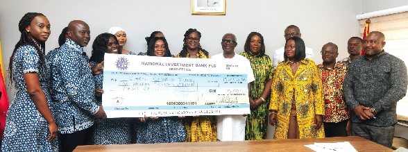 Kofi Adams (arrowed), Minister of Sports and Recreation, joins staff of NIB during the presentation ceremony