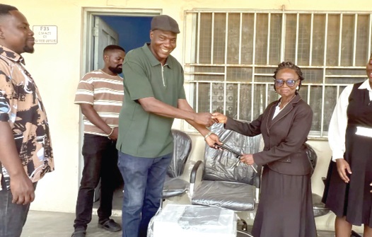 Maxwell Kwame Lukutor (left), MP for South Tongu, presenting the office equipment to a court official