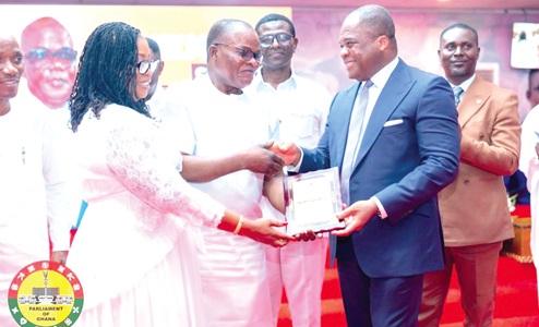 Rev. Stephen Yenusom Wengam (2nd from right), General Superintendent of the Assemblies of God, Ghana, presenting Ebenezer Ahumah Dzietror an award of significant achievement from the church