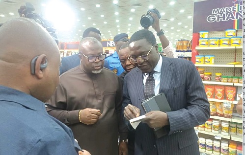 Dr Martin Kolbil Yamborigya (right) of the Domestic Tax Division of the Ghana Revenue Authority (GRA) assessing an invoice to verify its reconfiguration in line with the new VAT reforms. With him are Anthony Kwasi Sarpong (middle), Commissioner-General of the GRA, and other officials during a working visit