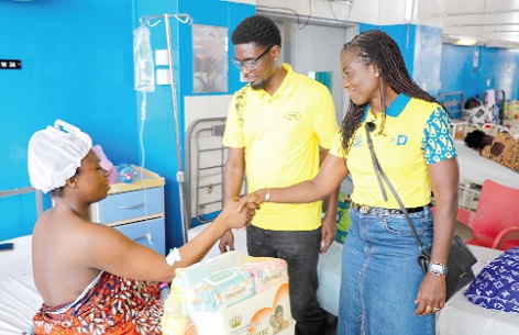 Adwoa Wiafe (right), Chief Corporate Services and Sustainability Officer of MTN Ghana, presenting a hamper to a mother at the Maternity Ward of Korle Bu Teaching Hospital. With them is Samuel Bartels, Senior Manager for Regulatory and Government Affairs at MTN Ghana. Picture: ELVIS NII NOI DOWUONA 