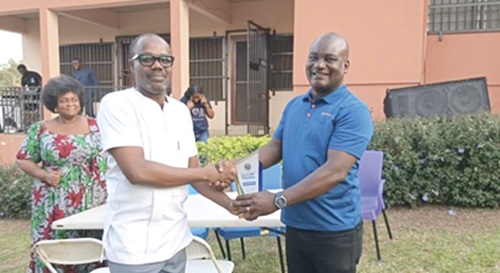 Peter Kofi Fletcher (left), General Manager presenting the plaque to Collins Manu, Head of PR