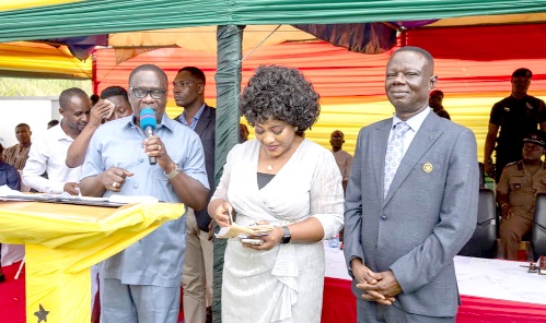 James Gyakye Quayson (left), Deputy Minister of Foreign Affairs and Regional Integration, addressing participants in the ceremony.  RIGHT: Some immigration officers at the newly opened Passport Application Centre at Sefwi Wiawso