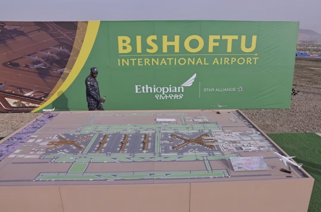 A member of the Ethiopian Federal Police walks past the Bishoftu International Airport design during its construction commencement in Abusera, Ethiopia, January 10, 2026. REUTERS/Tiksa Negeri