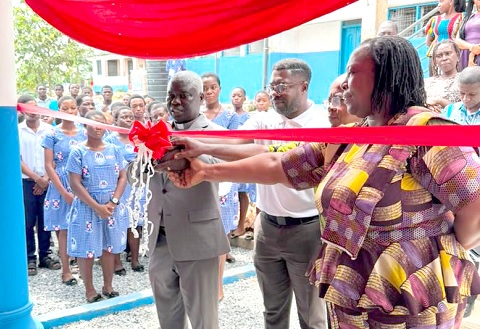Mary Lomokie Amlalo (right), Headmistress of the Presbyterian Senior High Technical School (PRESEC) at Adukrom in the Okere District, assisting Nii Ankonu Annorbah-Sarpei (2nd from right), KGLs Foundation's Head of Programs, to inaugurate the newly renovated 24-seater water closet toilet facility. Looking on are some students and teachers. INSET: The facility