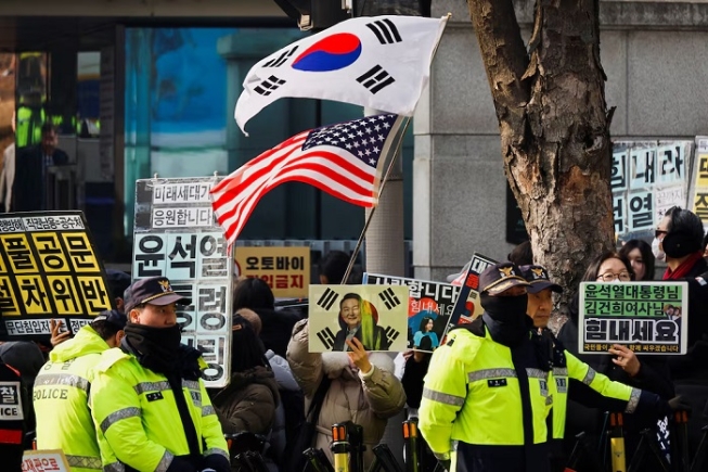 A group of far-right protesters gather to support former South Korean President Yoon Suk Yeol, before a bus carrying him arrives for a first court ruling in a case including obstruction of arrest, linked to his martial law declaration, at a court in Seoul, South Korea, January 16, 2026. REUTERS/Kim Soo-hyeon
