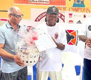 Rabbon Doddo (left), presenting a gift to DK Poison