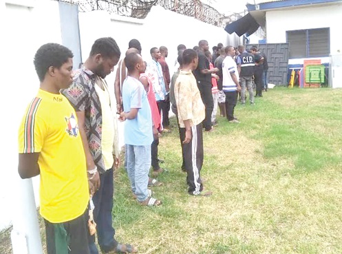 Some of the suspects as they were found at work in their hideout. Left: The suspects being screened before being taken into custody