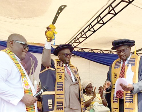 Prof. Ernest Kofi Abotsi (right), Chairman of Governing Council of ATU, and Very Rev. Fr Clement Wilson (left) swearing in Prof Amevi Acakpovi, Vice-Chancellor, ATU, at the investiture ceremony