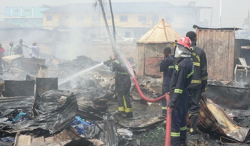 Firefighters trying to put out the fire that broke out at the informal settlement and market near the Circle Interchange